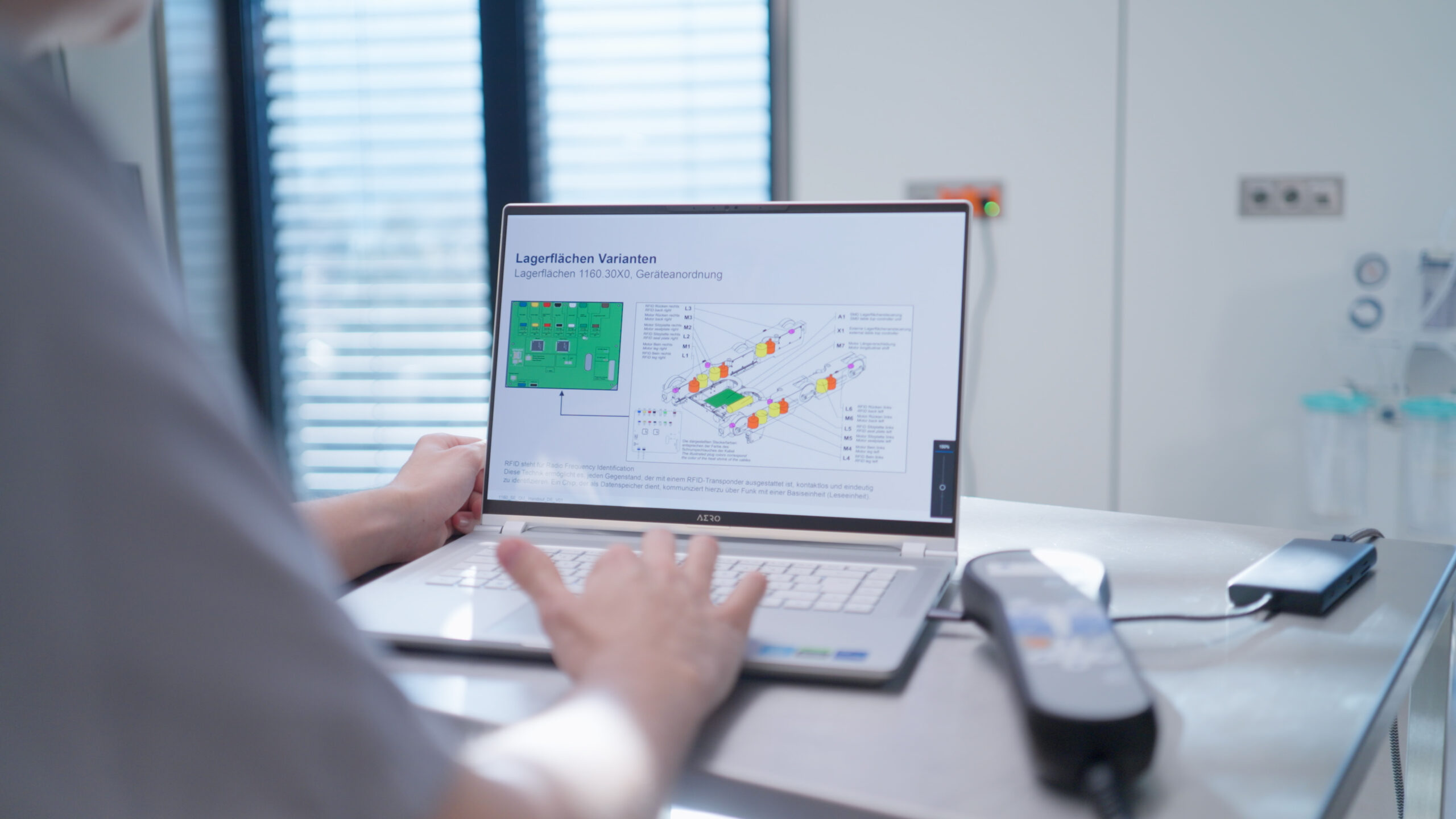 Laptop mit technischem Schema auf dem Bildschirm; Person bedient das Gerät.